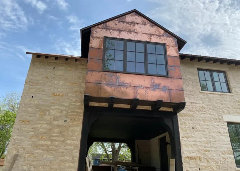 Copper metal panel facade on a stone building for Roof Repair in Austin