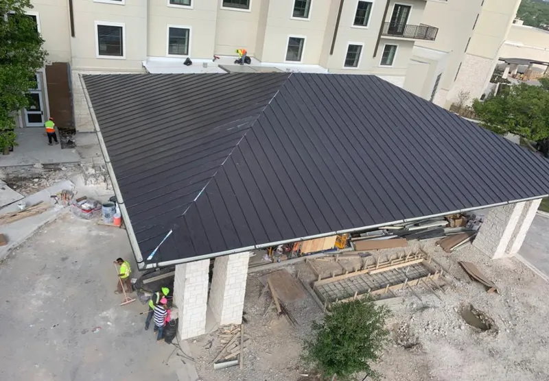 Metal roofing installation team working on a commercial building in Austin